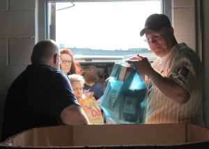 Volunteers from NorthRidge Fellowship in Rogers help unpack the CROSS van after the Stamp Out Hunger food drive May 9th. 