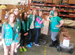 St. Michael and Albertville Girl Scouts (left to right) Kaelee Lindgren, Hannah Hughes, Claire Parendo, Tommie Treptau, Felicia Lutz, Sydney Amundson, and Emily Thell (back) collected and delivered 781 pounds of food and 70 pounds of books to donate to CROSS in May. (Photo provided by Teresa Lutz)
