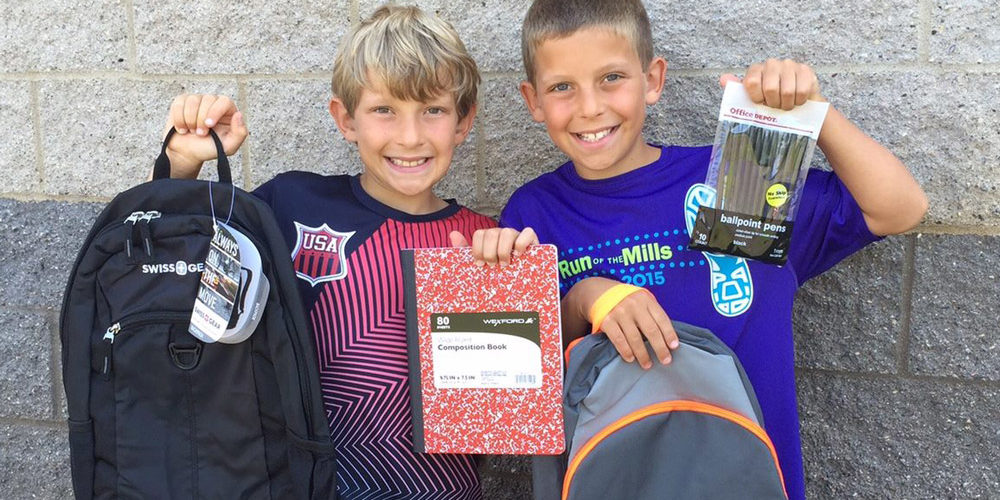 Children holding backpack and school supplies